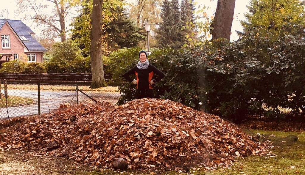 Sonja Stadje steht in einem sehr großen Laubhaufen, altes Bild von 2017