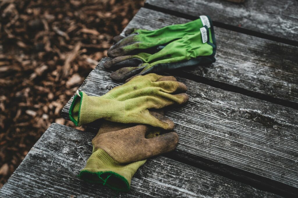 Gartenhandschuhe liegen auf einem Holzdeck