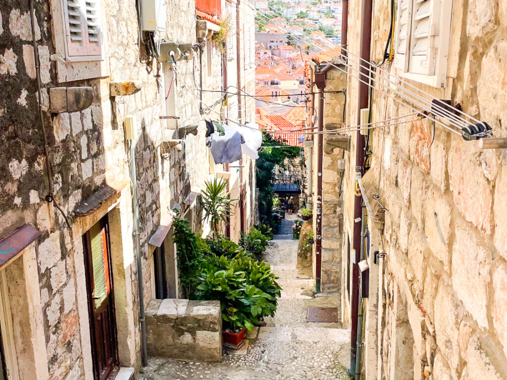 Schattige, schmale Gasse zwischen hohen Häusern in einer kroatischen Stadt
